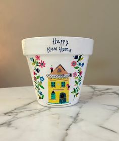 a white cup sitting on top of a table with a happy new home written on it