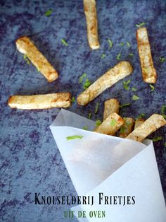 some food is laying out on a blue tablecloth with the words knoesledeiu frittes ut de oven