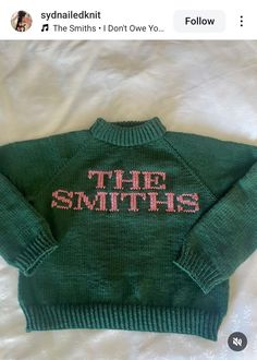 a green sweater with the words'the smiths'written in pink on it