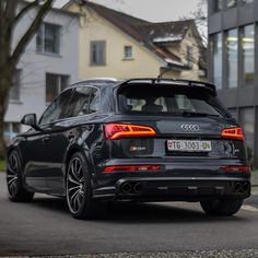 the rear end of an audi suv parked in front of a building