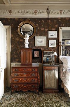 a bedroom with a dresser, mirror and pictures on the wall