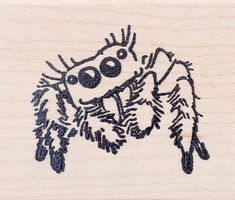 a wooden stamp with an image of a spider on it's face and legs