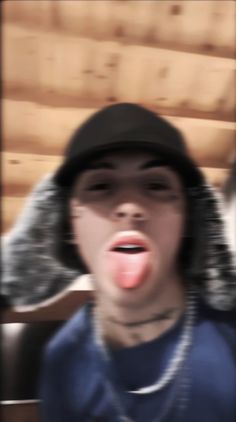 a blurry photo of a person with his tongue out and wearing a black hat