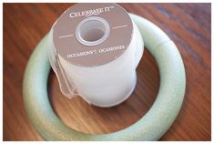 a spool of thread sitting on top of a wooden table next to a green ring