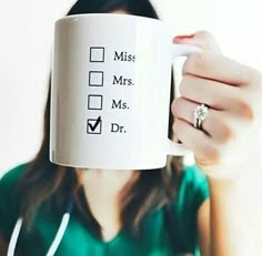 a woman holding up a coffee mug with the words miss, mrs, and dr on it