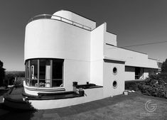 a white building sitting on top of a lush green field