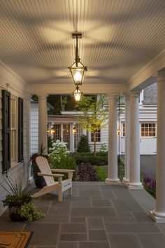 a porch with a bench and lamp on it