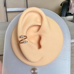 a fake ear with two small diamonds on it's side, sitting on top of a plastic stand