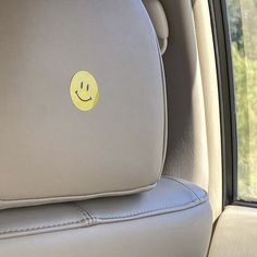 a smiley face sticker is on the back seat of a car's headrest