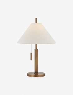 a table lamp with a white shade on the top and a gold base, against a white background