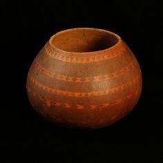 a brown vase sitting on top of a black table