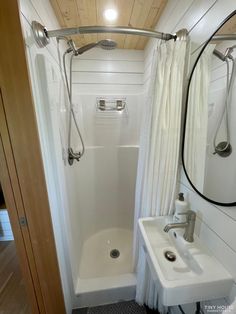 a bathroom with a shower, sink and mirror