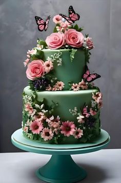 a green cake with pink flowers and butterflies on it