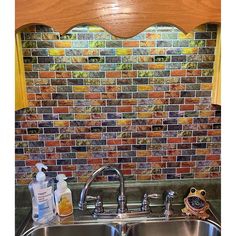 a kitchen sink under a window next to a faucet and soap dispenser