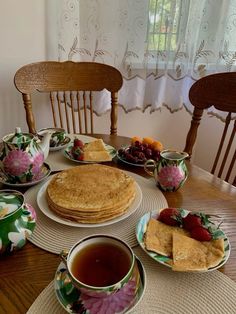 a table topped with plates and cups filled with food