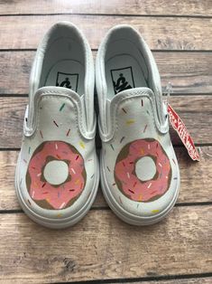 Hand Painted Donut Vans Perfect slip-on shoes for the donut loving toddler in your life. The images above are a toddler Vans in size 7. The design can be created on any size vans - be sure to choose your size when checking out. There is a donut hand-painted on the front of both shoes. The sides have different color sprinkles scattered around the shoe. It takes about three weeks (sometimes quicker!) until the shoes are ready to be shipped! If you need the shoes to be shipped sooner than that, ple Painted Vans Ideas, Custom Vans Ideas, Vans Ideas, Shoe Artwork, Hand Painted Toms, Rainbow Vans, Painted Converse, Vans Custom, Painted Shoes Diy