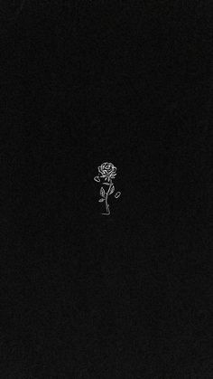 a black and white photo of a person with a rose on their head in the dark