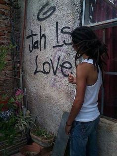 a woman writing graffiti on the side of a building