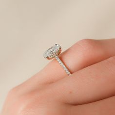 a woman's hand with a diamond ring on top of her finger, showing the side view