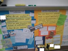 a bulletin board with several different types of notes on it and people standing in the background