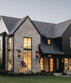 a large brick house with lots of windows on the front and side of it's roof