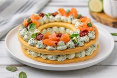 an elaborately decorated cake is displayed on a white plate with green leaves and cucumbers