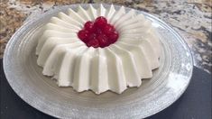 a cake with white icing and raspberries on top