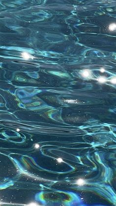 an image of water that is very blue and has bubbles on the surface in it