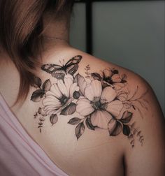 a woman's back shoulder with flowers and butterflies on her upper half - arm