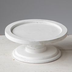 a white cake plate sitting on top of a table