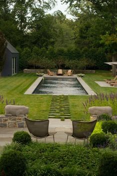 an outdoor pool surrounded by lawn furniture and landscaping