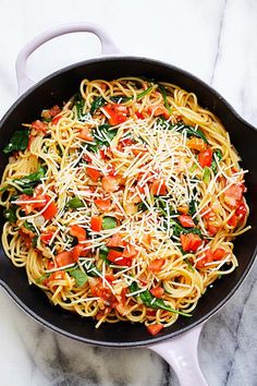 a skillet filled with pasta and vegetables