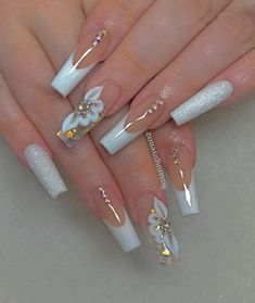 some white and gold nail designs with flowers on the tip of each one, while others are