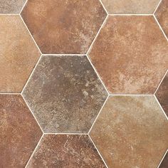 a tile floor with brown and tan hexagonal tiles on it's sides