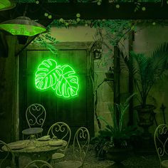 a green neon sign in the middle of a room with tables and chairs around it