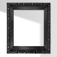 an old black frame hanging on the wall with a shadow from it's reflection