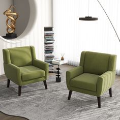 two green chairs sitting on top of a rug in a living room next to a lamp