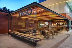 an outdoor dining area with tables and chairs under a canopy that reads casco on it