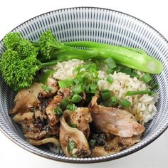 a bowl filled with chicken, rice and broccoli on top of a table