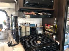 a stove top oven sitting inside of a kitchen next to a microwave and coffee maker