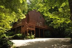 a wooden house surrounded by trees in the woods