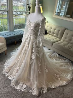 a wedding dress on display in front of a couch