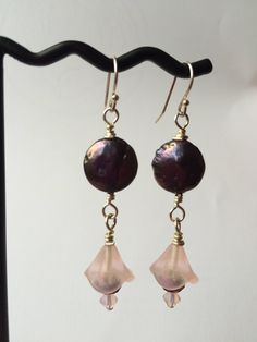 Unique black coin pearls falling from sterling ear hooks hold pretty frosted pink flowers in a long drop earring pair. The flowers are finished off with a purply-gold faceted rondelle and a pink opal Swarovski crystal bicone bead, and have a beautiful, feminine appeal. Elegant Adjustable Flower Earrings With Round Beads, Elegant Pink Round Bead Flower Earrings, Elegant Pink Round Beaded Flower Earrings, Flower Drop Earrings, Coin Pearls, Long Drop Earrings, Ear Hook, Drop Earring, Pink Opal