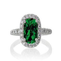 an emerald and diamond ring on a white background