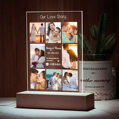 a wooden block with photos on it next to a potted plant and a candle