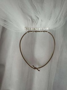 a headband with the word love written on it and two small white beads hanging from each end