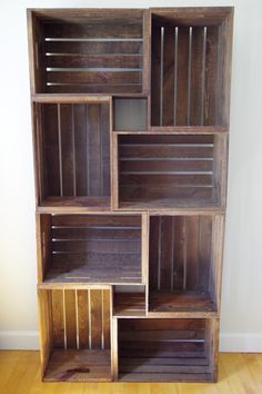 a wooden bookcase with multiple compartments on the front and back sides, sitting on top of a hard wood floor