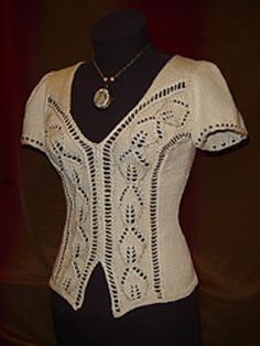 a mannequin wearing a white knitted top with an intricate design on it