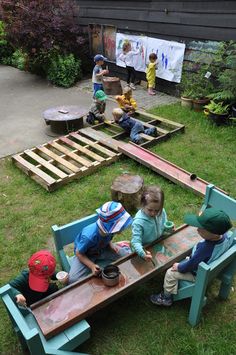 children are playing with wooden toys in the yard on some lawn furniture made out of pallets