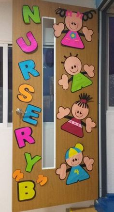 a wooden door decorated with children's pictures and letters that spell out the word nursery